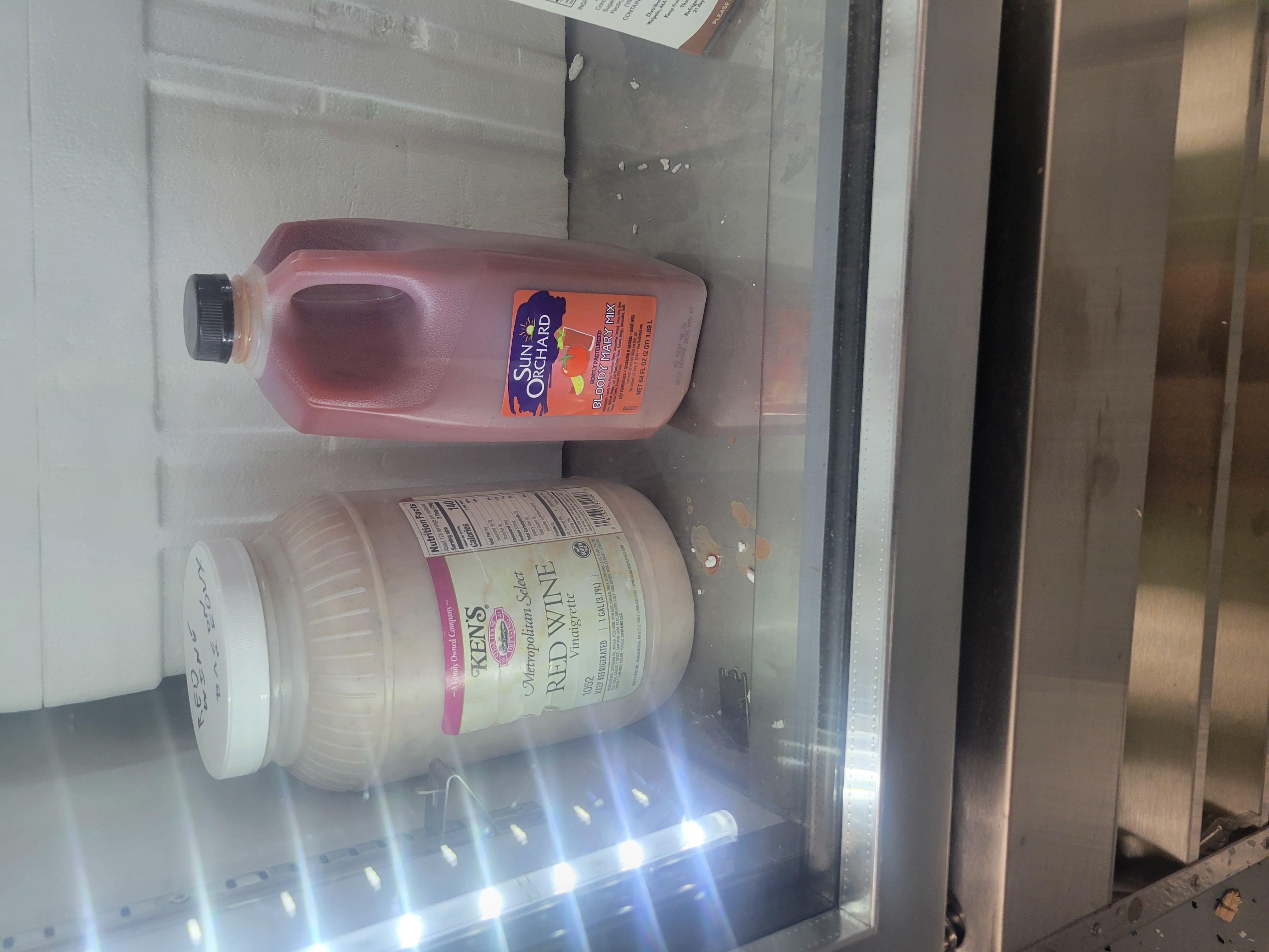 Gallon container of red wine vinaigrette and 2 quarts bottle of bloody mary mix.